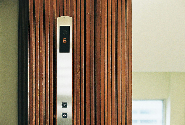 Close-up of elevator control panel with up and down buttons representing residential elevators for seniors