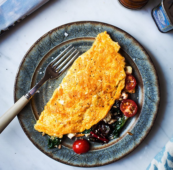 Post-workout omelet with rainbow chard, cherry tomatoes, feta cheese, and sesame seeds.