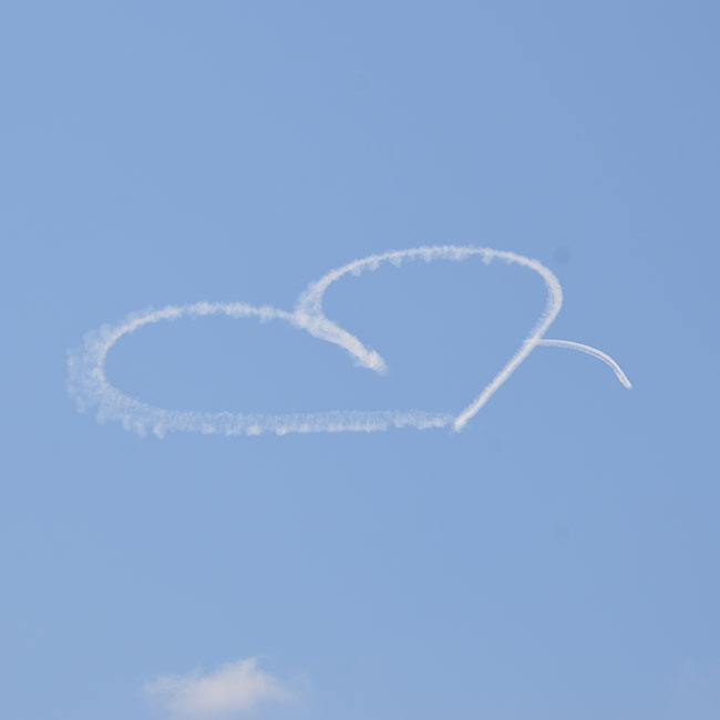 Heart drawn in the blue sky by a skywriting aircraft
