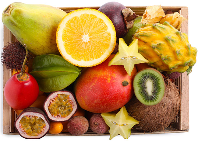 Assortment of colorful tropical fruits including star fruit, passion fruit, kiwi and dragon fruit